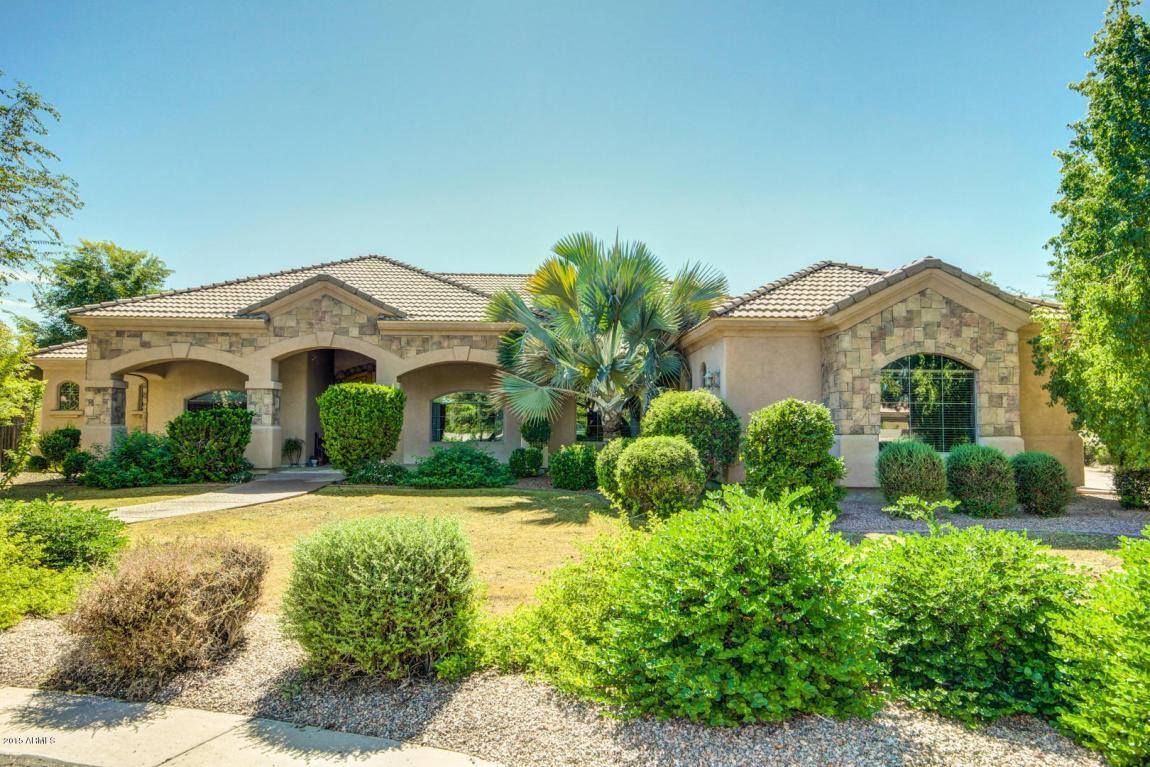 A large house with a lot of bushes in front of it.