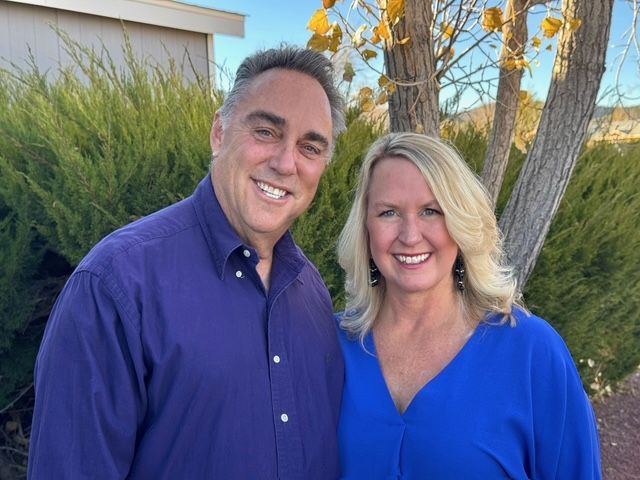 A man and a woman are standing next to each other and smiling