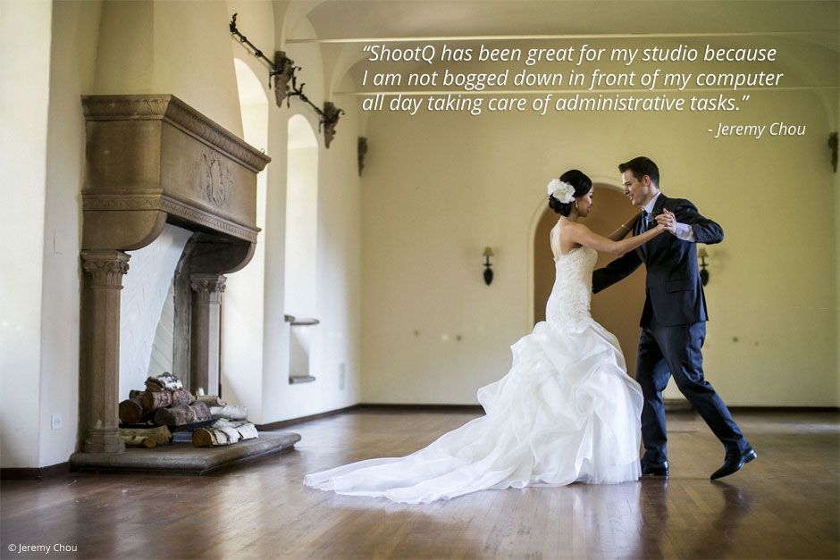 A bride and groom are dancing in a room with a fireplace.