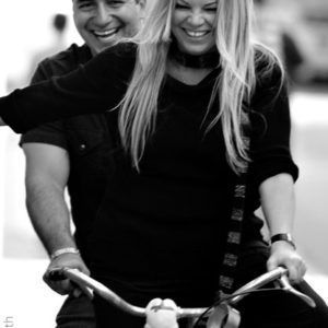 A black and white photo of a man and woman riding a bike