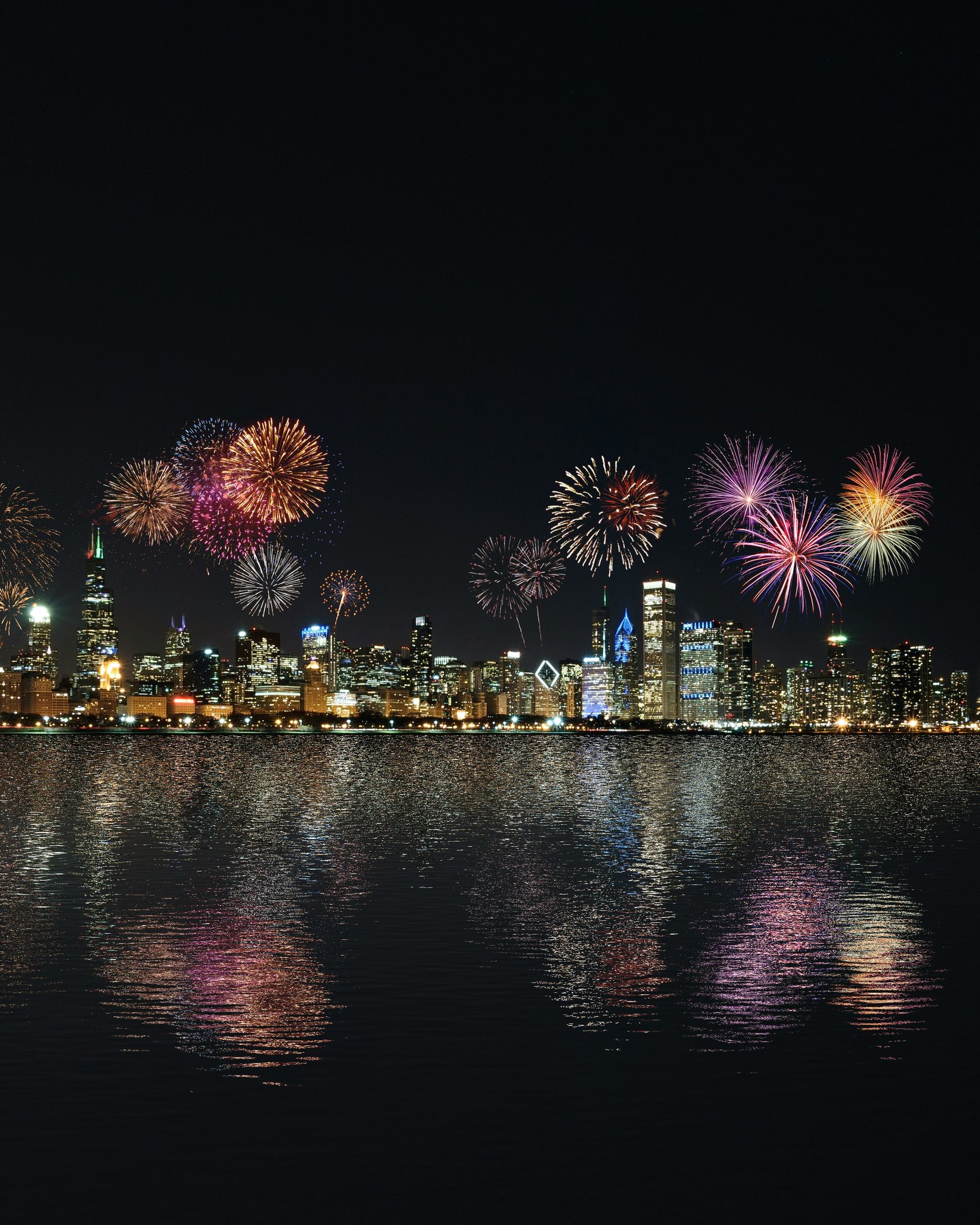 Fireworks are displayed over a city at night