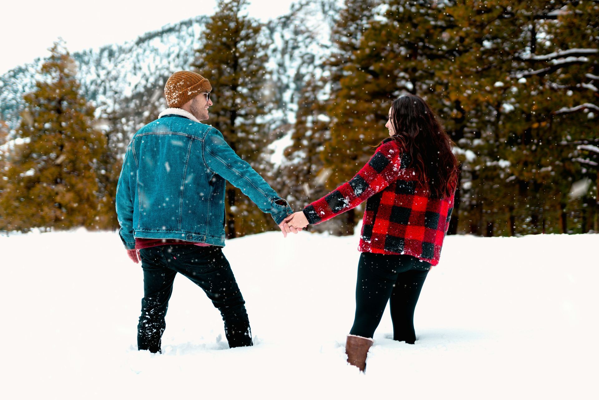 A man and a woman are holding hands in the snow.