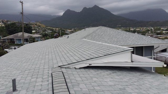 A roof of a house with mountains in the background.
