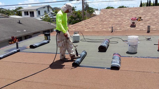 A man is working on the roof of a house.