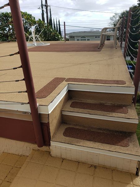 A set of stairs leading up to a deck with a railing.