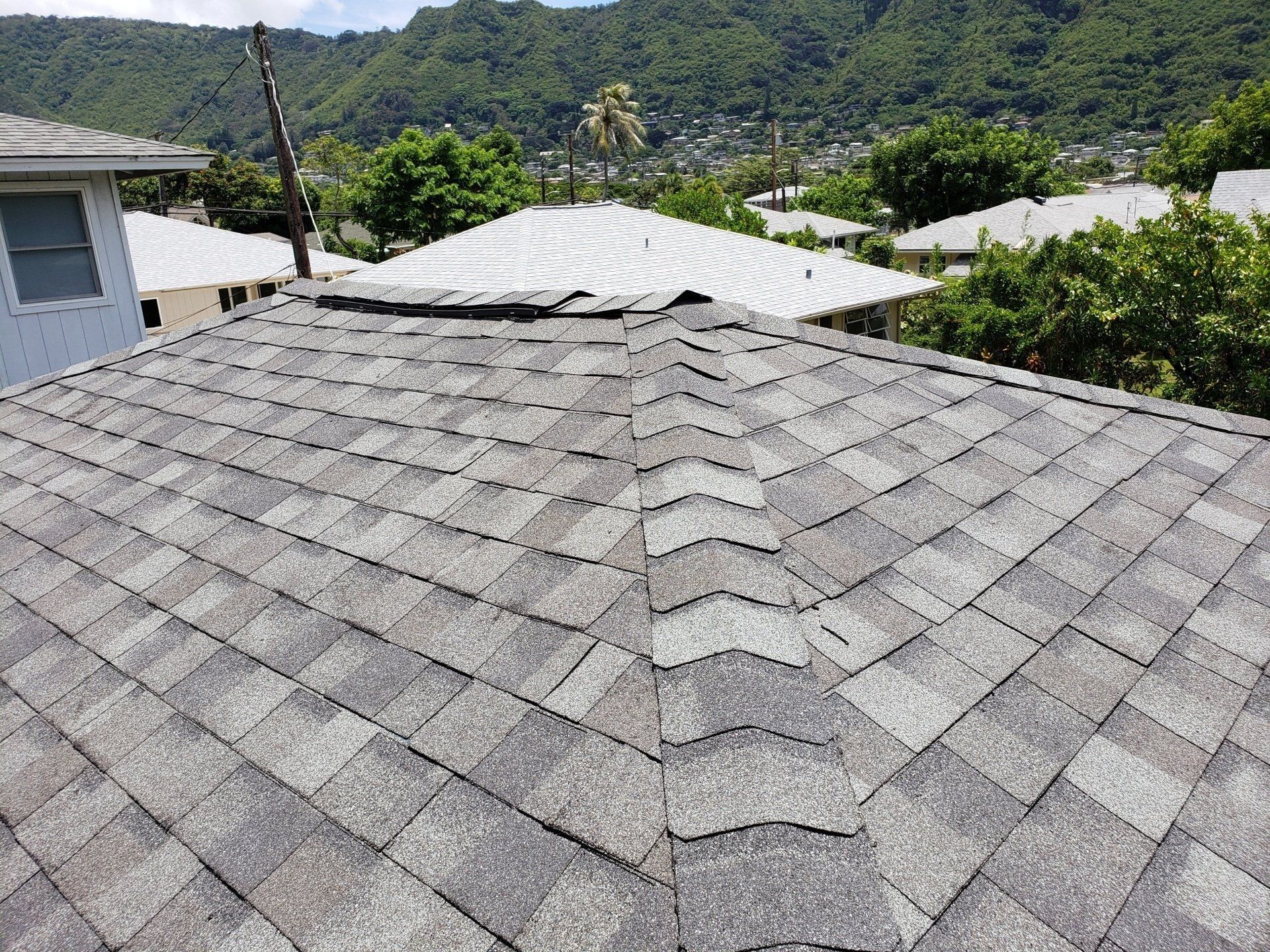A close up of a roof with a valley in the background.
