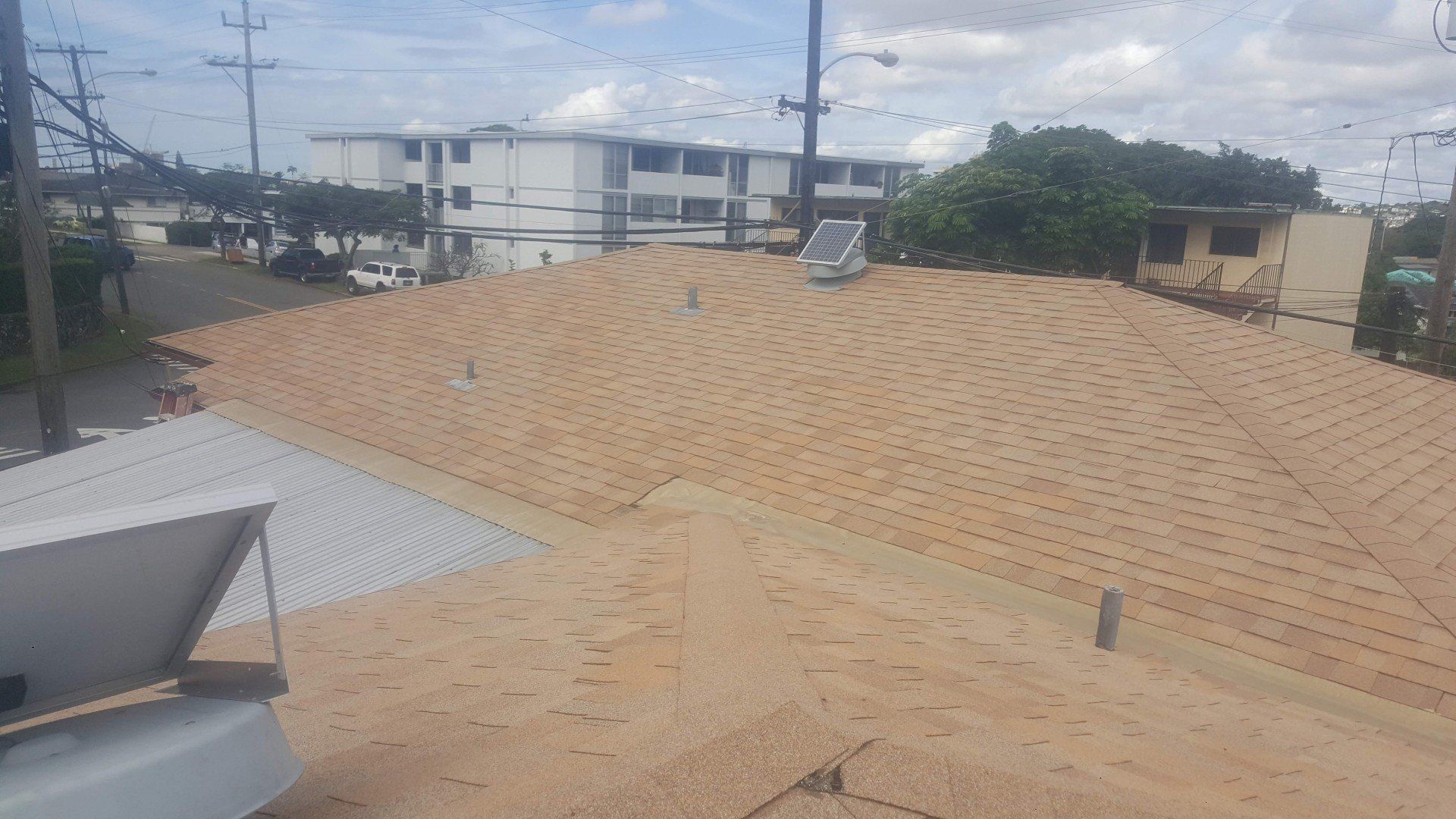 A roof with a lot of dirt on it and a building in the background.