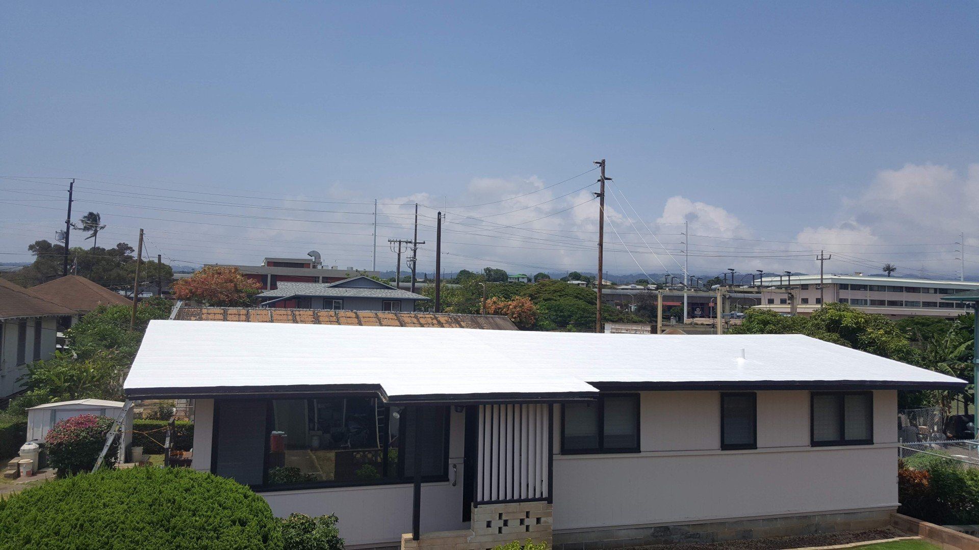A white house with a white roof and a blue sky in the background.
