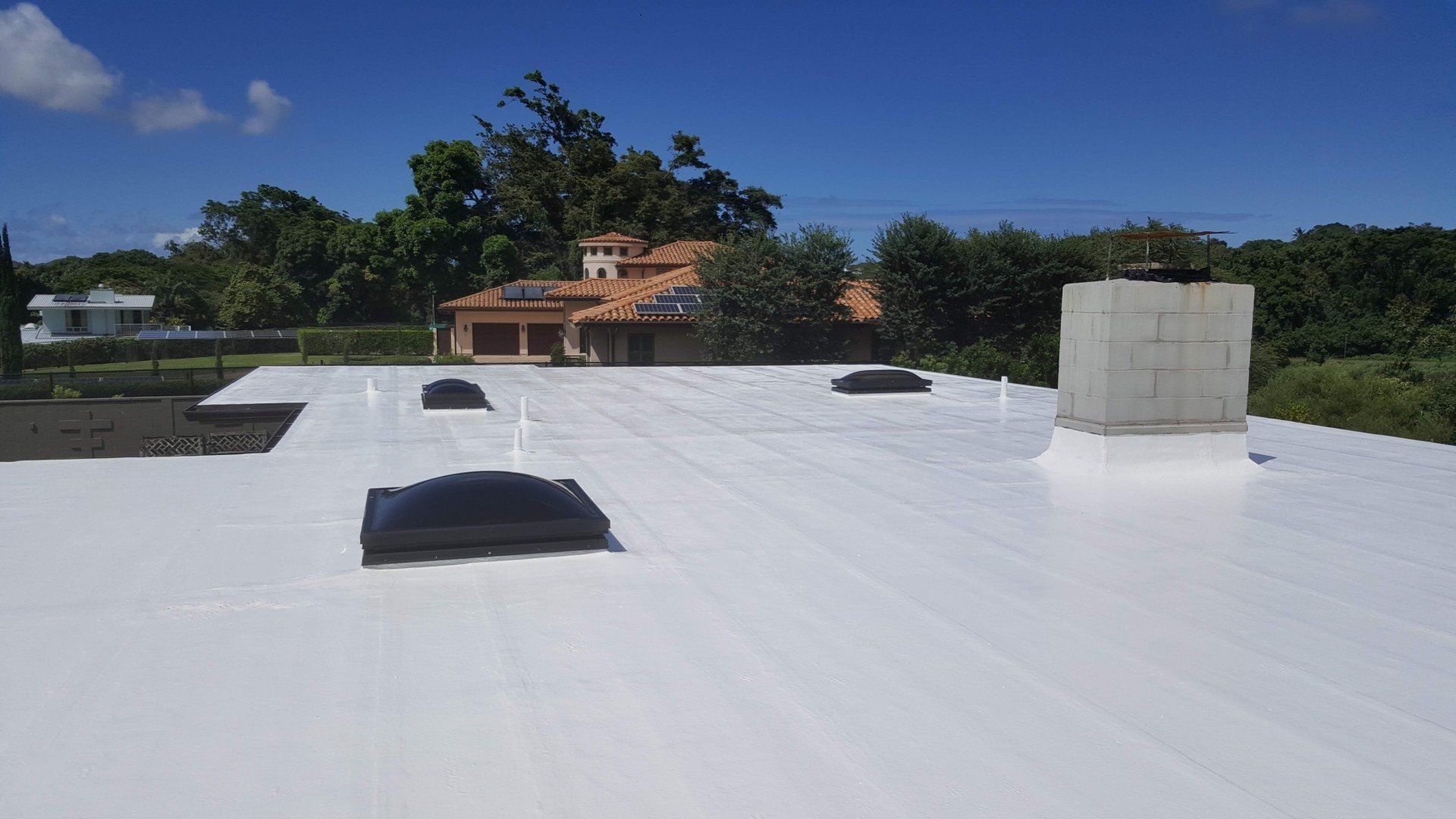 A white roof with a chimney on top of it.