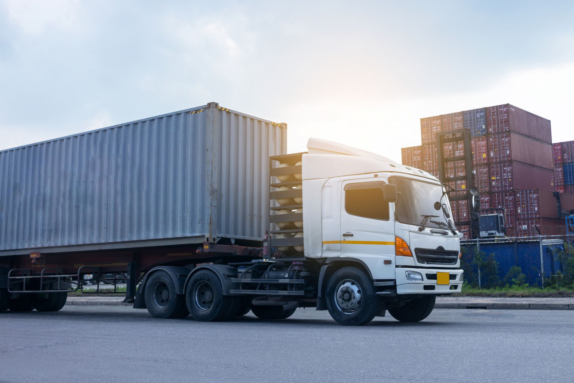 A white truck with a container on the back is driving down the road.
