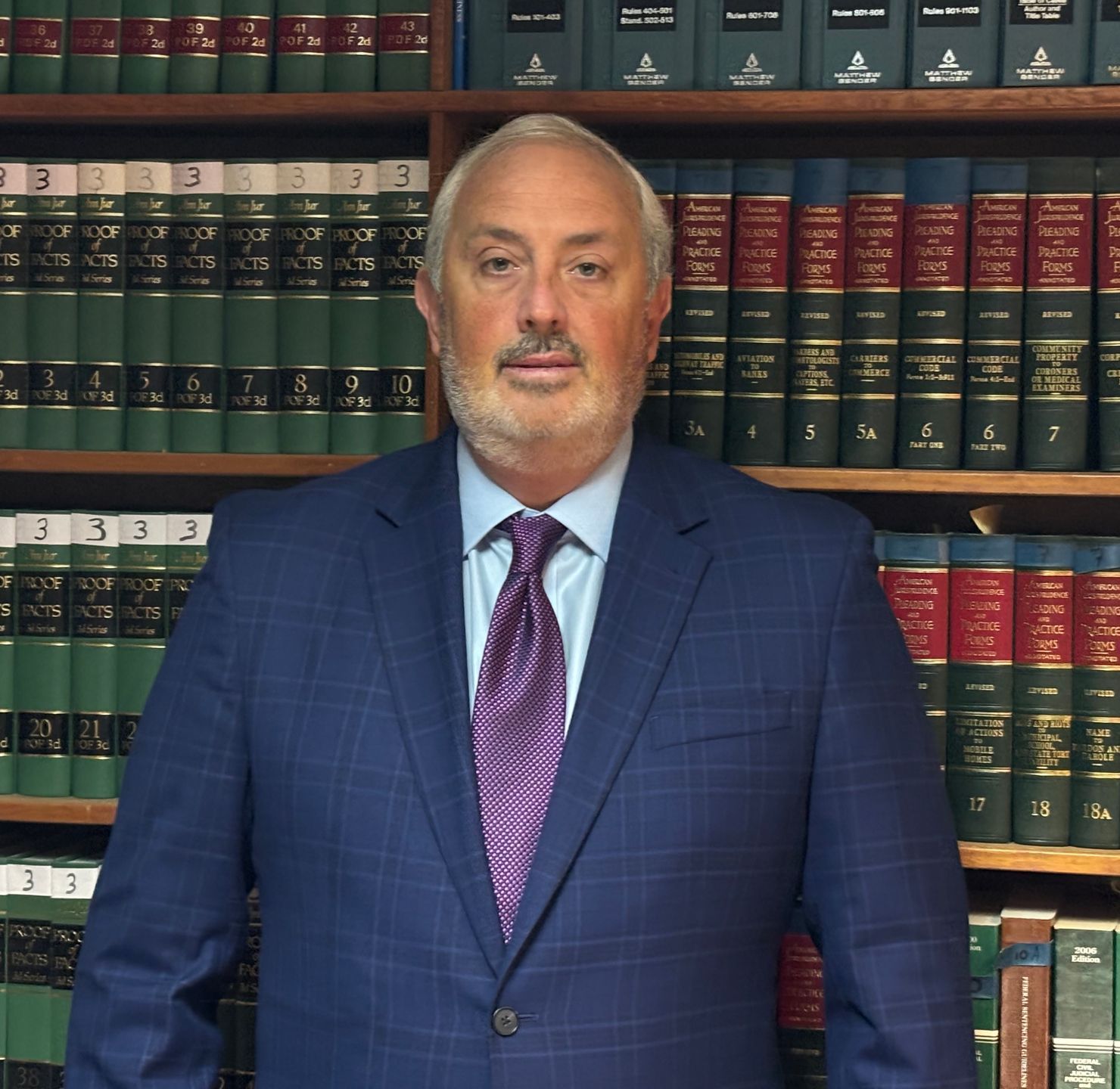 A man in a suit and tie is smiling for the camera