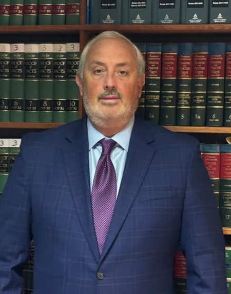 A man in a suit and tie is smiling for the camera
