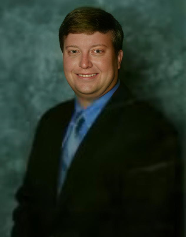 A man in a suit and tie is smiling for the camera.