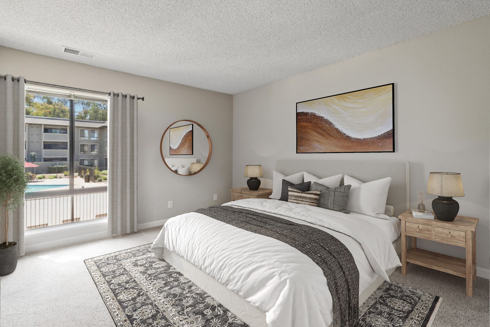 Bedroom in an apartment with a bed, two nightstands, lamps, wall art, and a pool view through a large window.