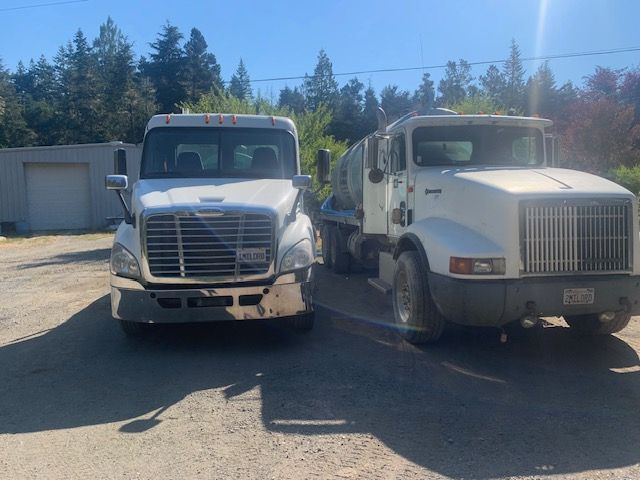A man is pumping a hose into a septic tank.