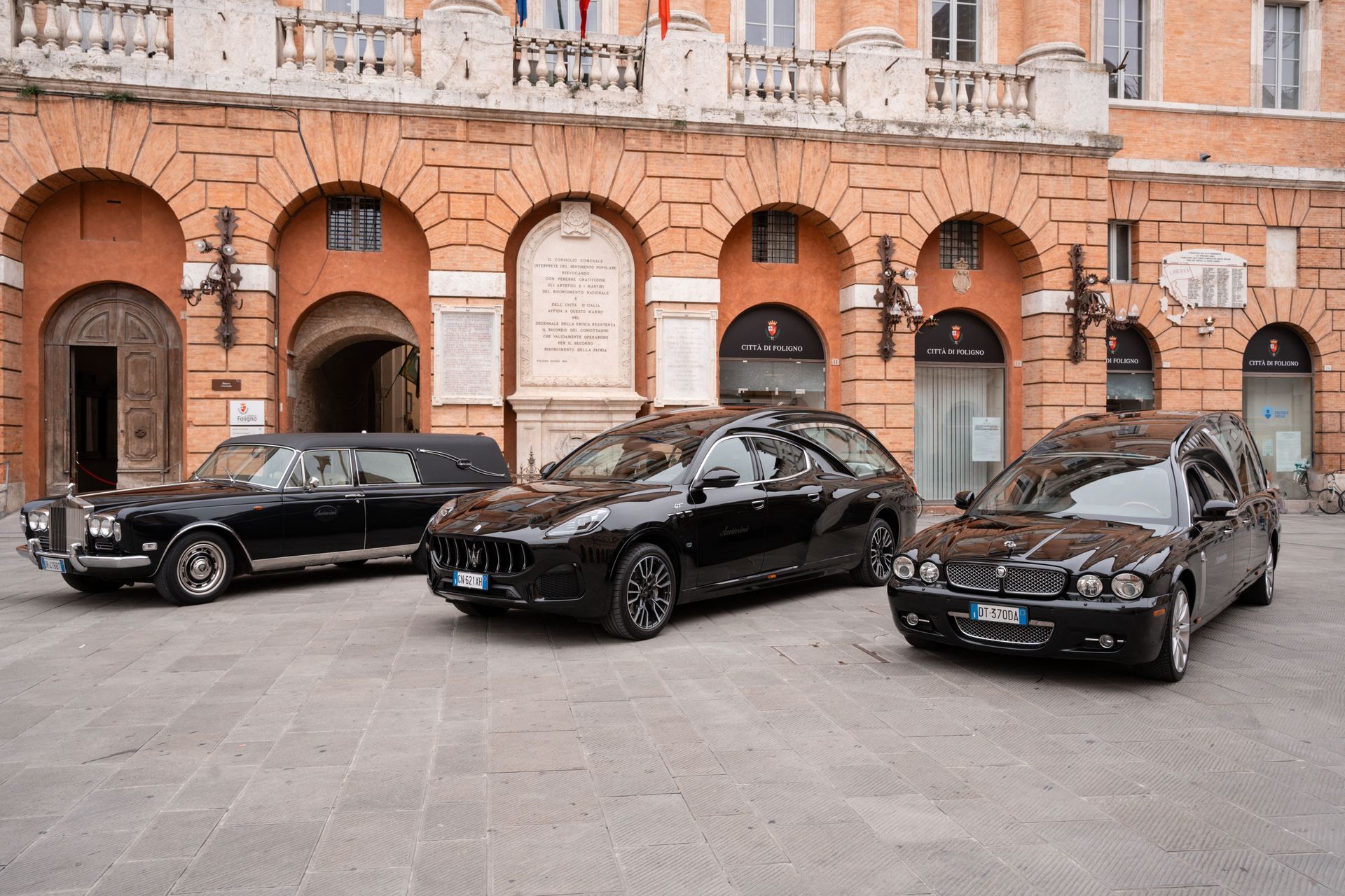 Tre auto nere sono parcheggiate davanti a un edificio.