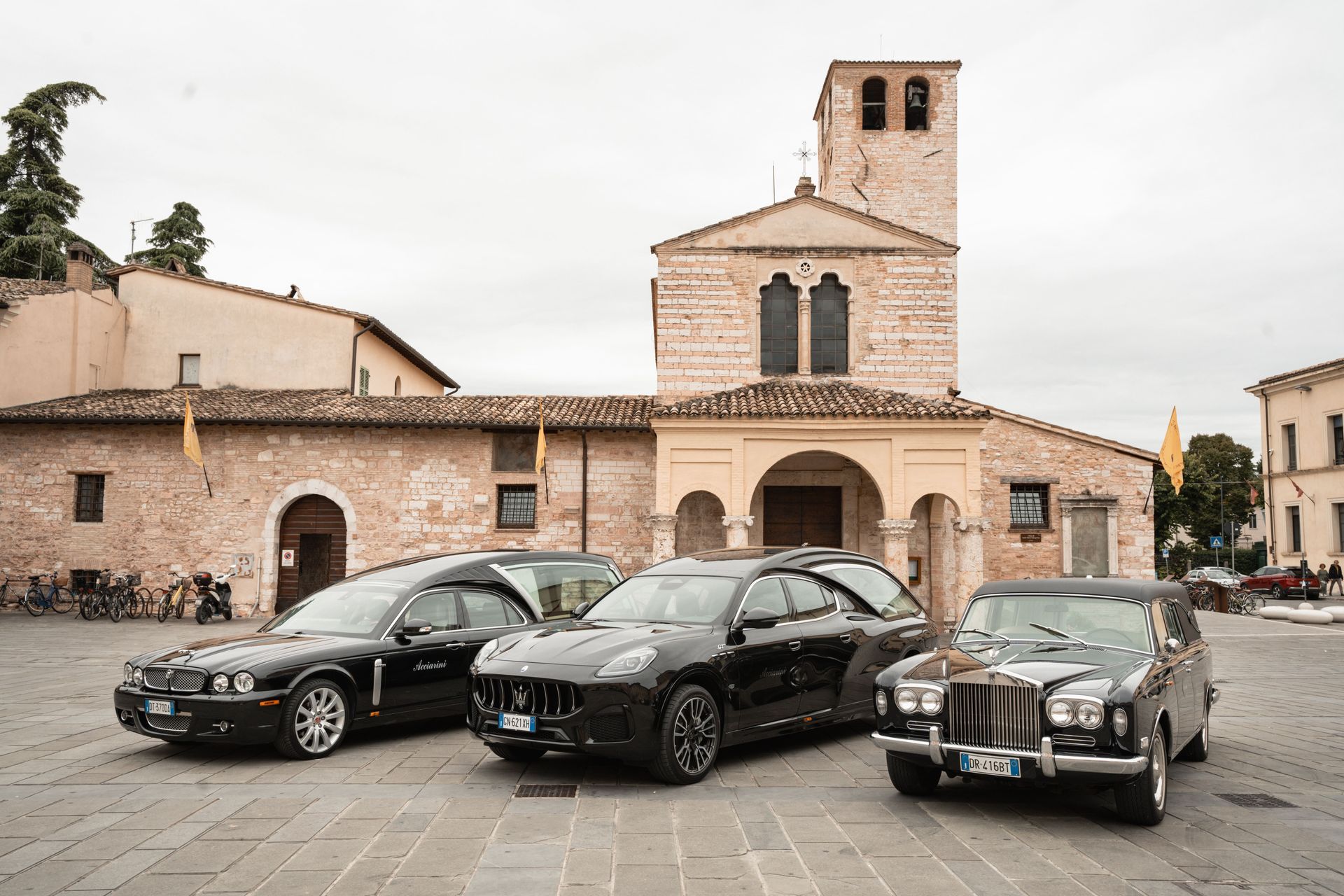 Tre auto nere sono parcheggiate davanti a una chiesa.