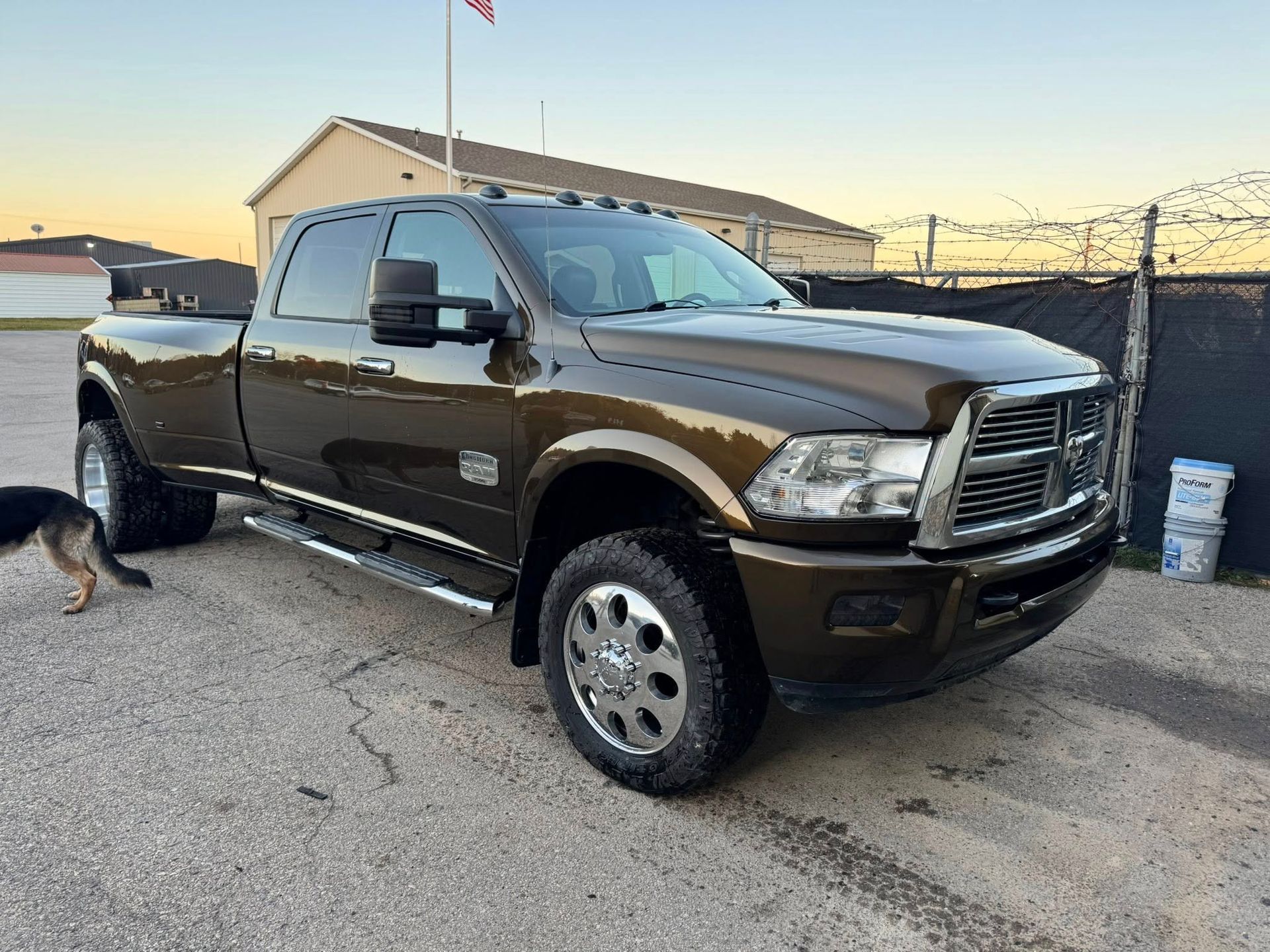 A metallic brown, heavy-duty dually pickup truck parked on a gravel lot during the daytime.