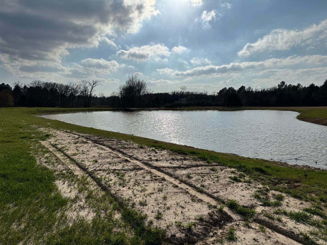 There is a large body of water in the middle of a field.