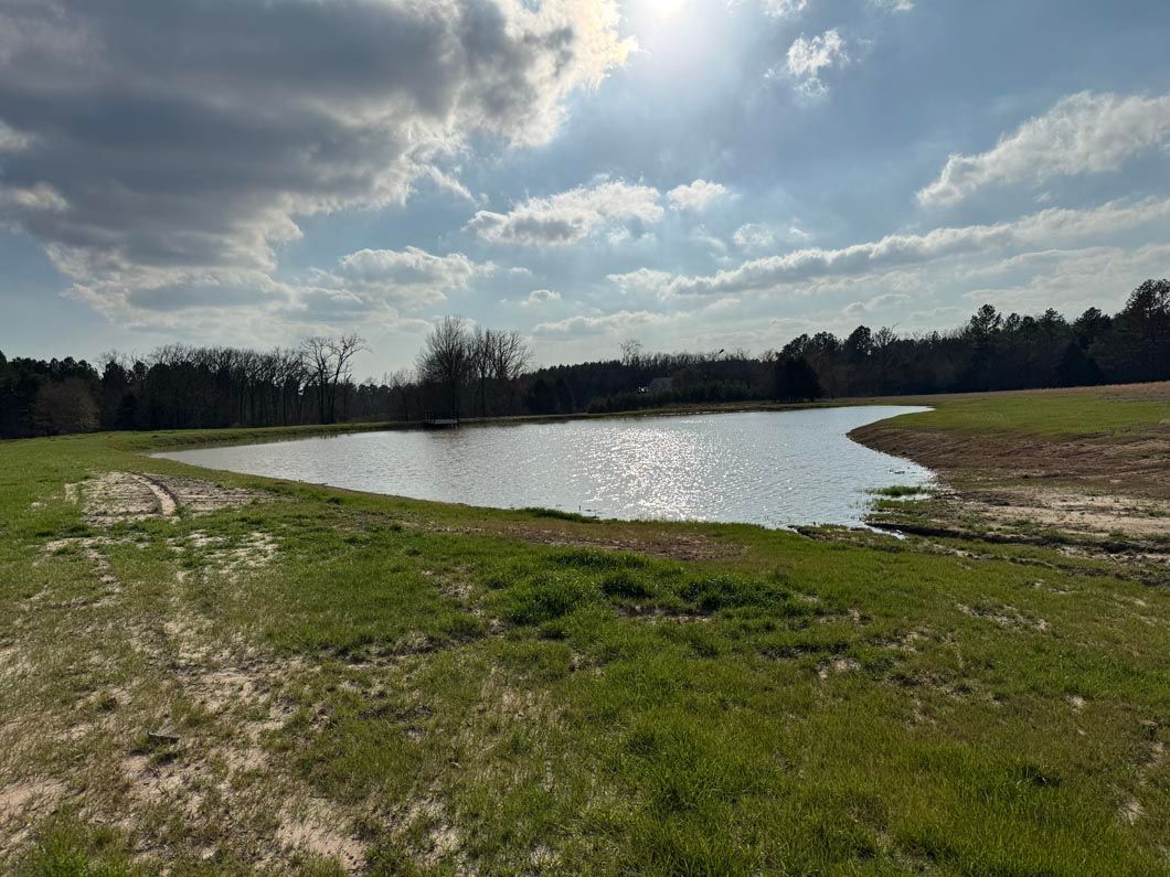 There is a large body of water in the middle of a field.