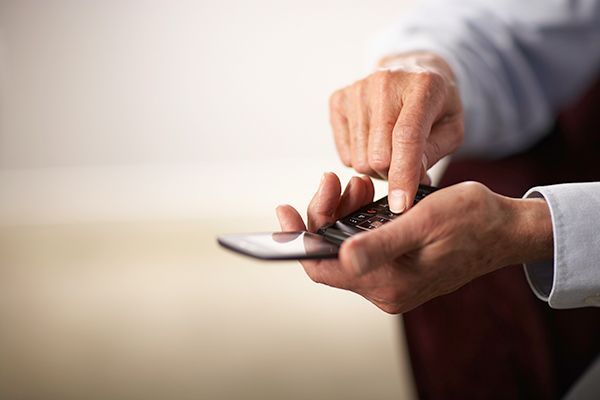 A person is holding a cell phone in their hands and using it.