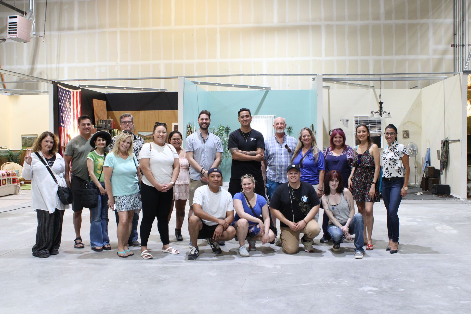 A group of people are posing for a picture in a large room.