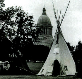 A black and white photo of a teepee in front of the capitol building