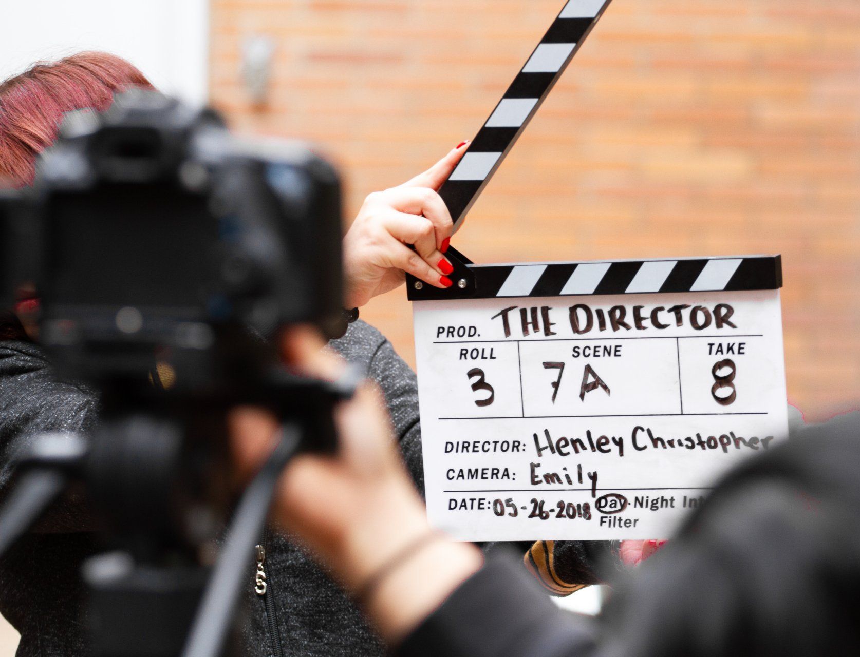 A woman is holding a clapper board that says the director