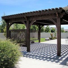 A wooden pergola with a lattice fence behind it