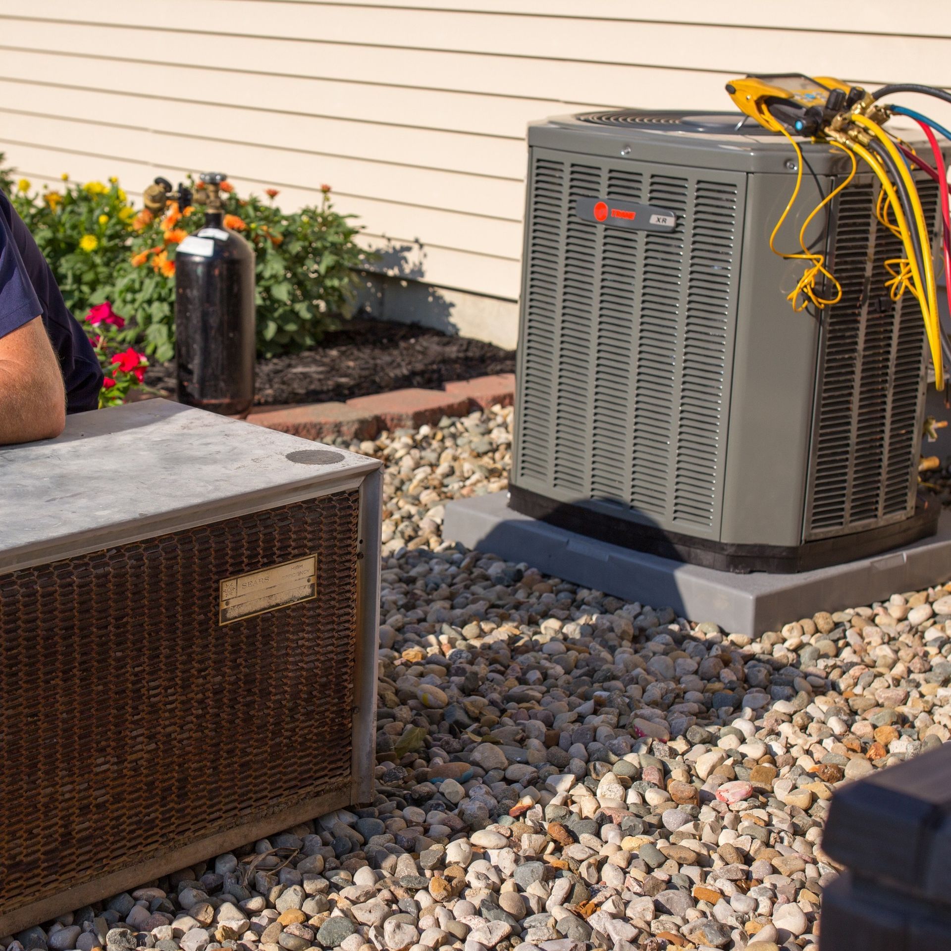 A man and woman standing in front of an air conditioner
