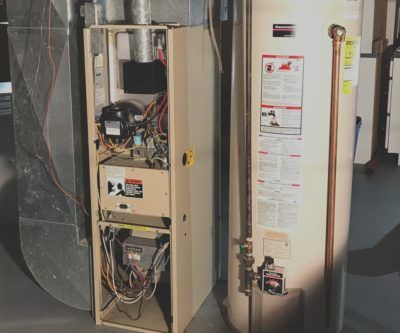 A heater and a water heater are sitting next to each other in a room.