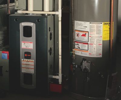 A water heater and an air conditioner are sitting next to each other in a room.