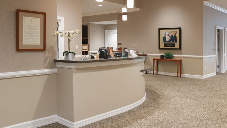 A reception desk in a hallway with a picture on the wall above it