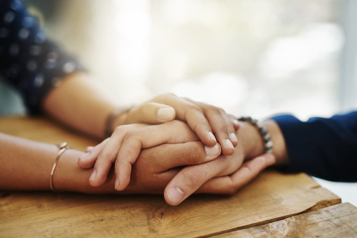 A man and a woman are holding hands on a table.