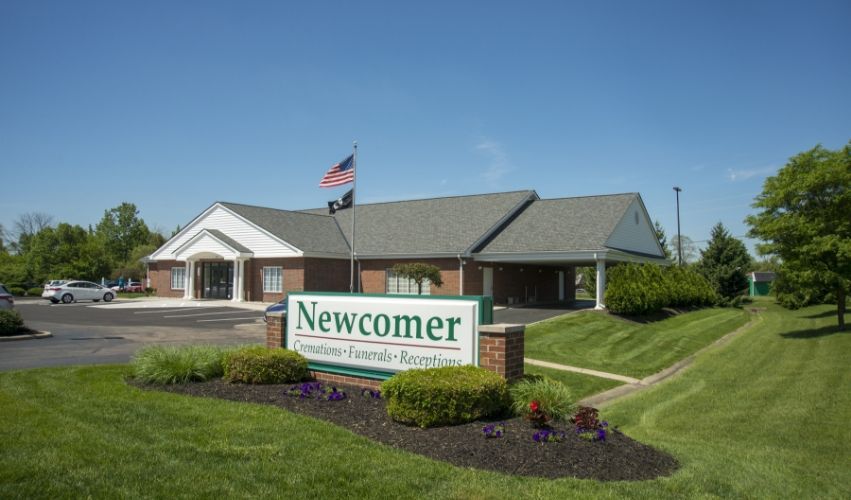 A newcomer building with a sign in front of it