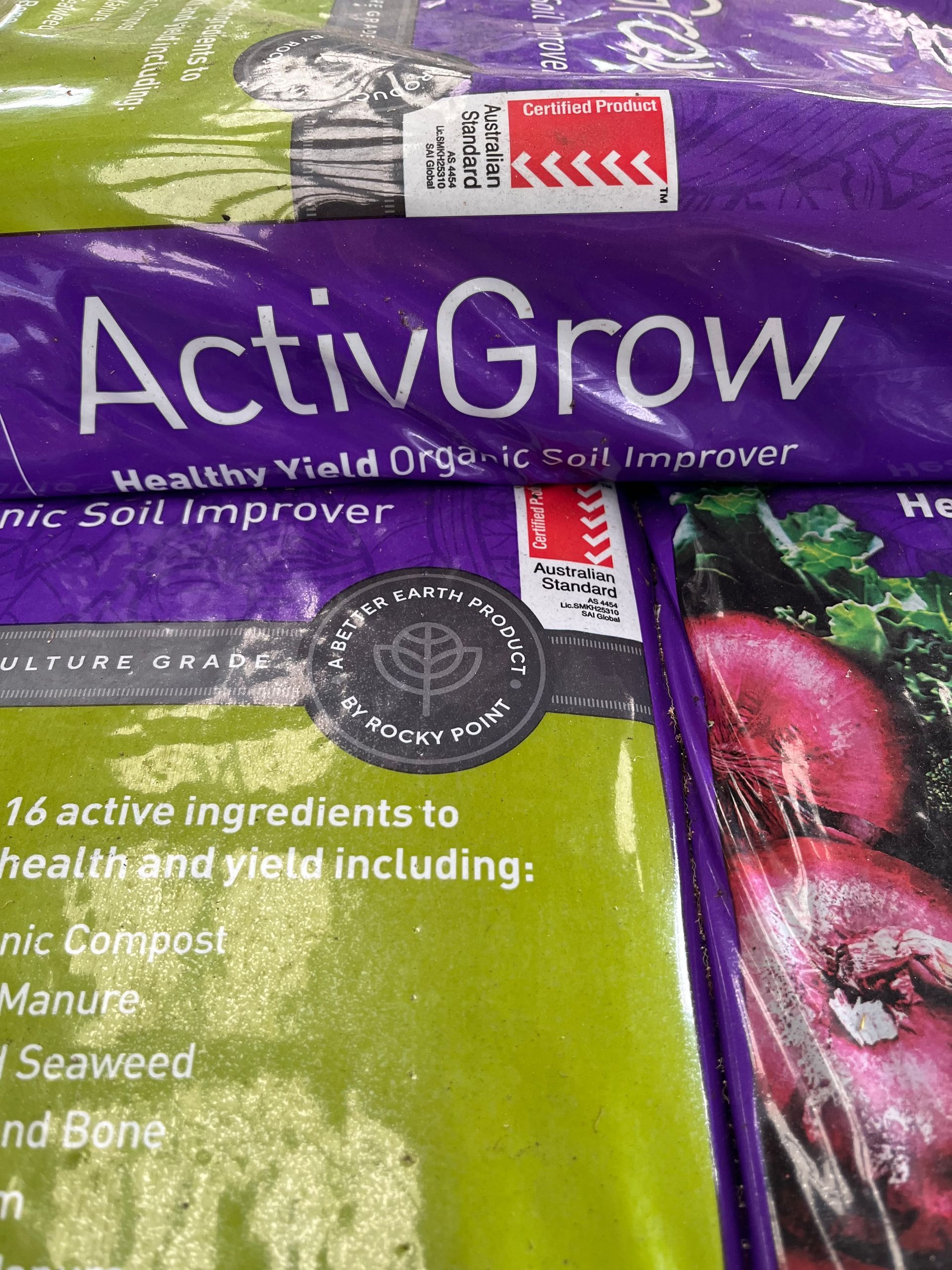 A Person in Blue Gloves Is Pouring Fertilizer Into a Bag — Gnomes Landscape & Garden Supplies In Taree South, NSW
