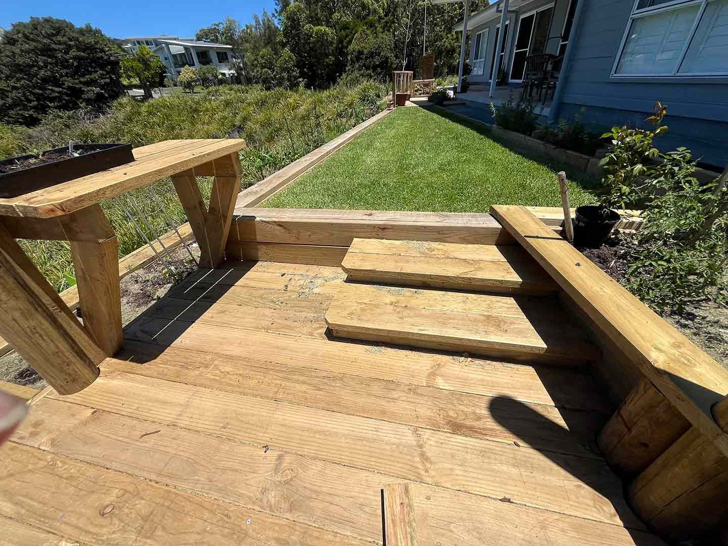 A Wooden Deck With Stairs Leading Up To A Grassy Yard — Gnomes Landscape & Garden Supplies In Hallidays Point, NSW