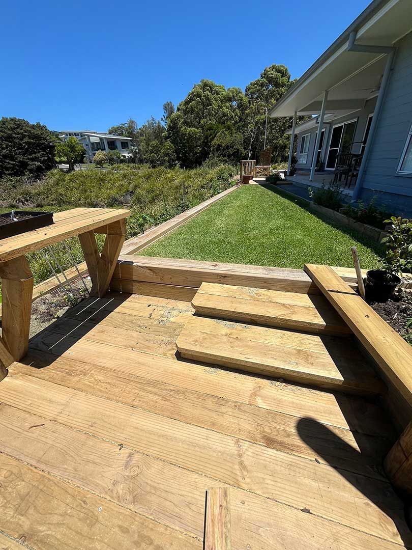 A Wooden Deck With Stairs Leading Up To A House — Gnomes Landscape & Garden Supplies In Taree South, NSW