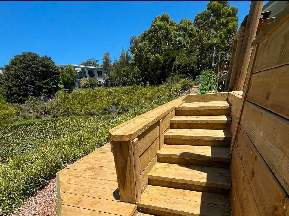 A Wooden Bench Is Sitting Next To A Wooden Fence — Gnomes Landscape & Garden Supplies In Taree, NSW