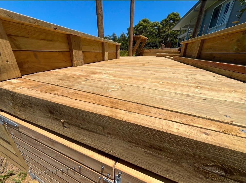 A Wooden Deck Is Being Built In Front Of A House — Gnomes Landscape & Garden Supplies In Wingham, NSW