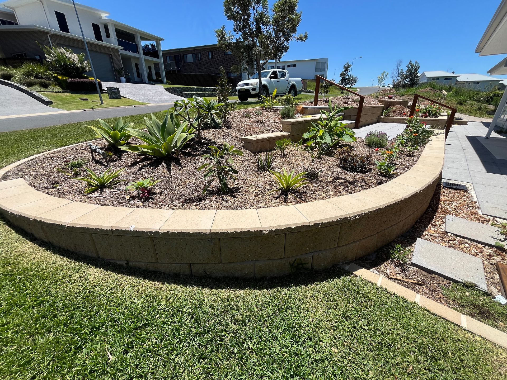 A Person Wearing Gloves Is Holding a Wheelbarrow Full of Dirt — Gnomes Landscape & Garden Supplies In Old Bar, NSW