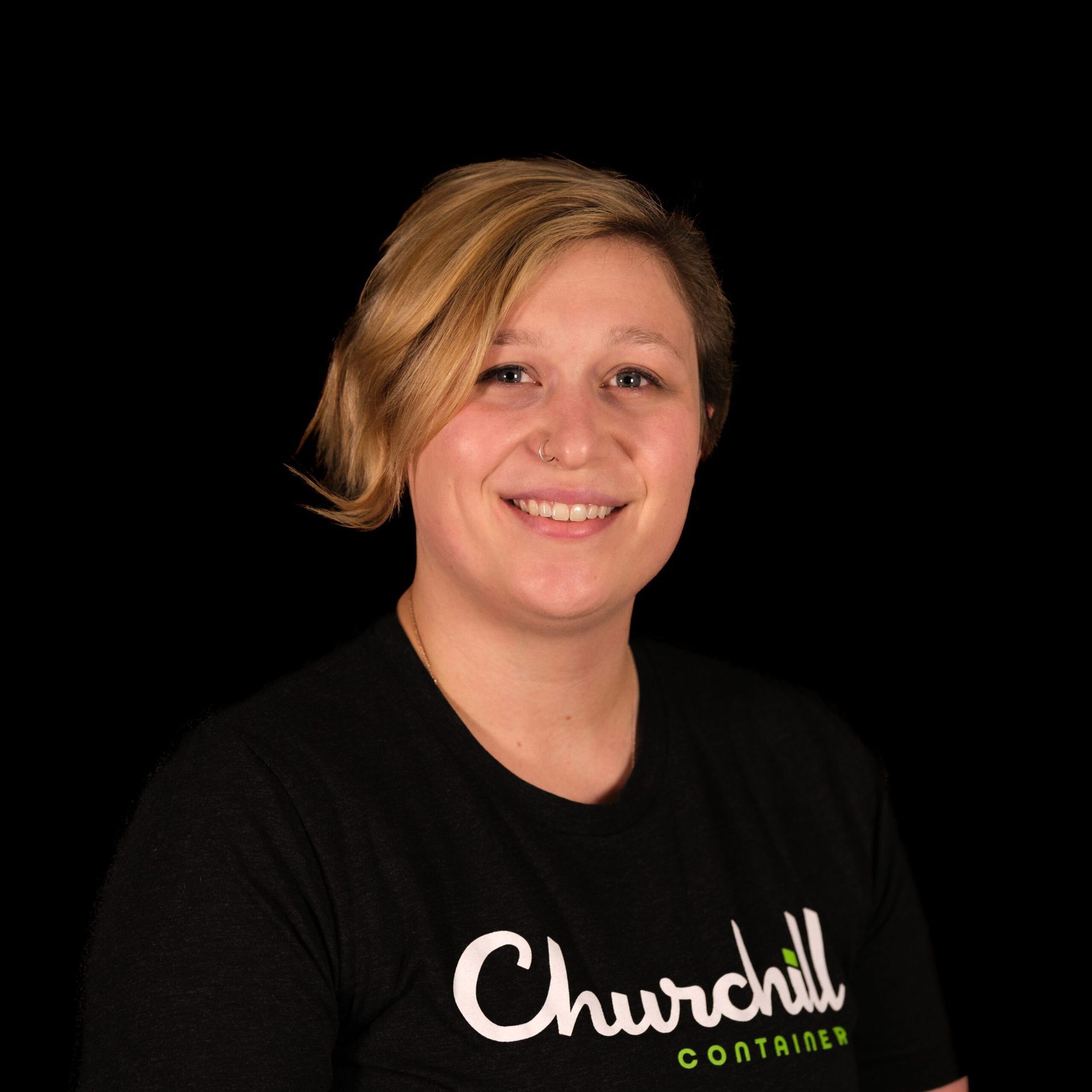 Woman with short blonde hair smiling, wearing a black shirt with 