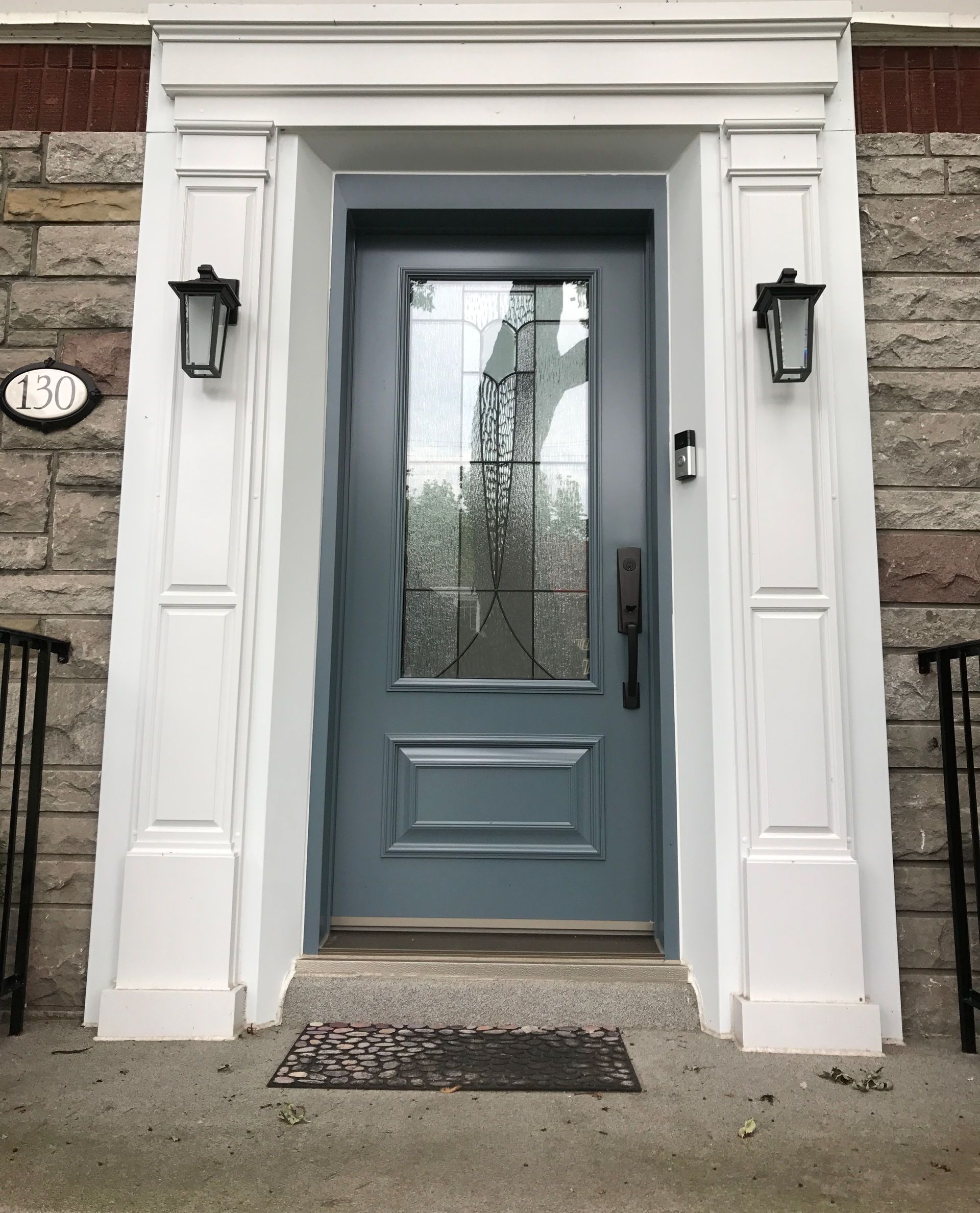 La porte d'entrée d'une maison avec une porte bleue et une garniture blanche.