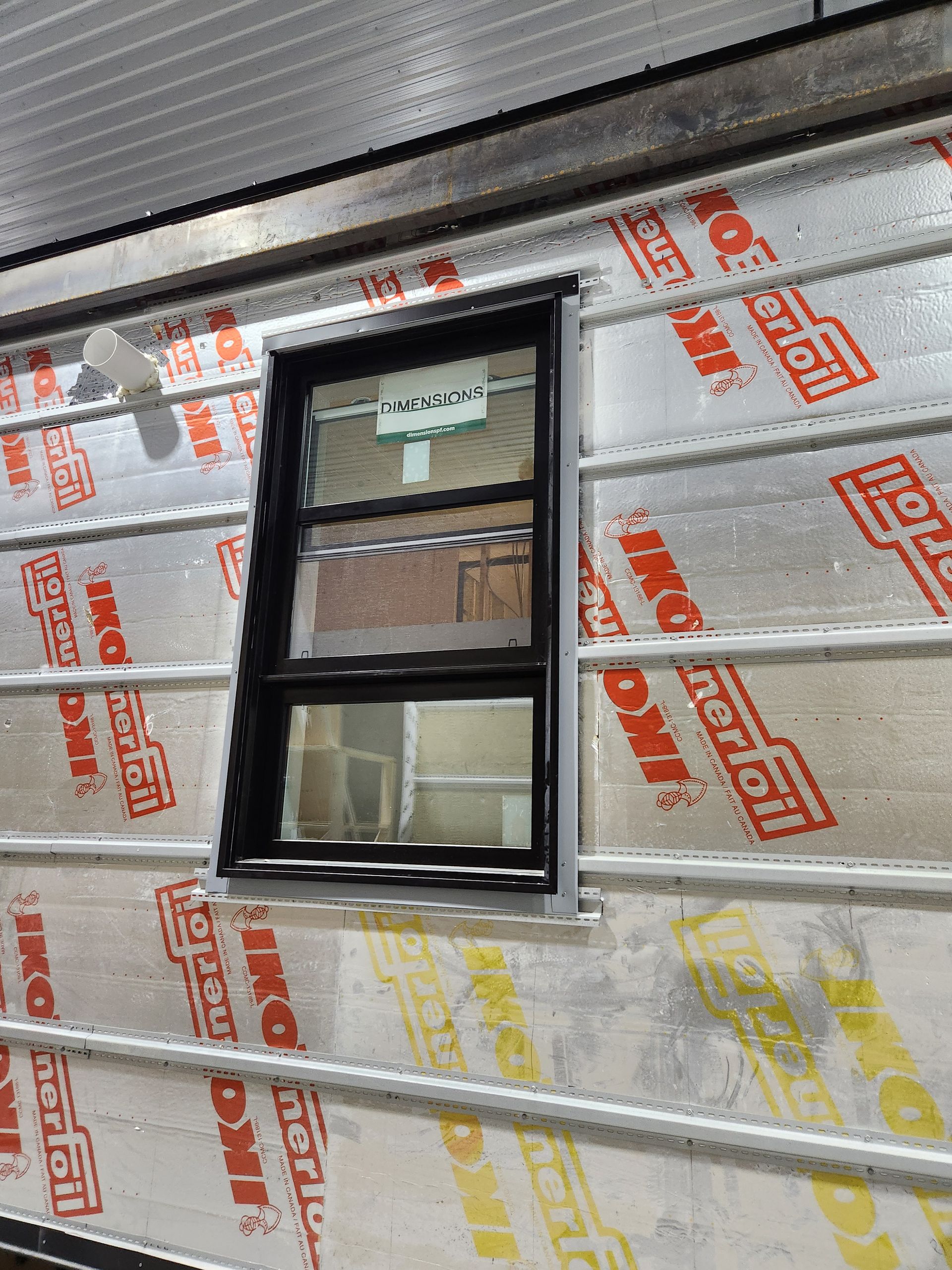 Une fenêtre sur le côté d'un bâtiment qui est recouverte d'isolant.