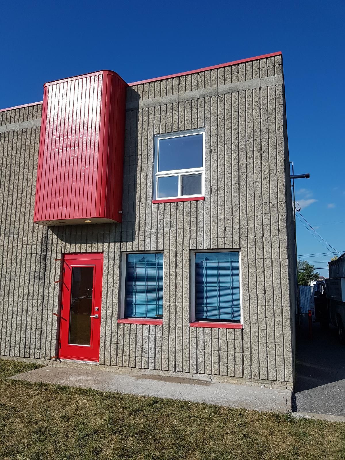 Un bâtiment en brique avec une porte et des fenêtres rouges