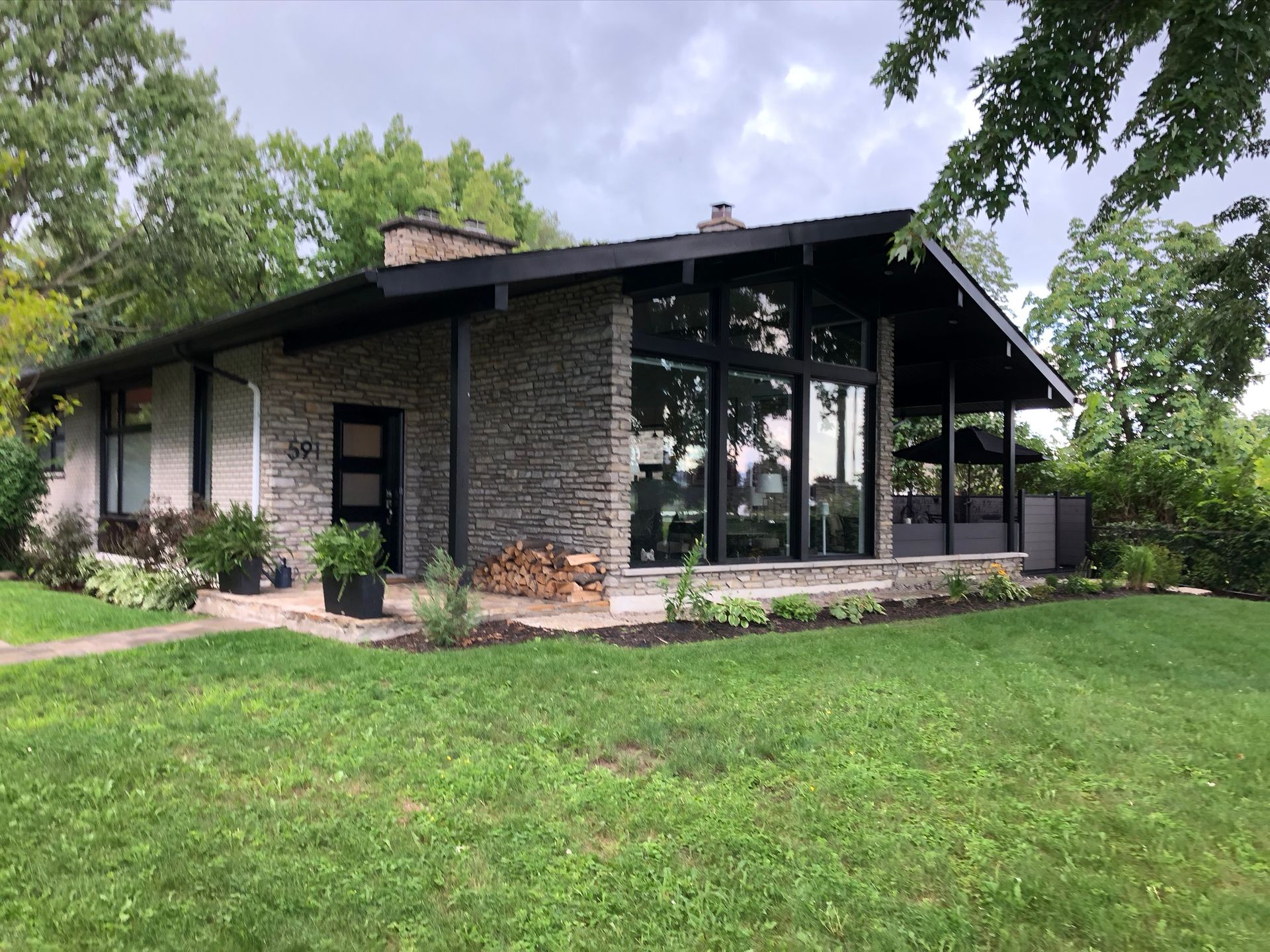Une grande maison avec beaucoup de fenêtres et une grande pelouse devant