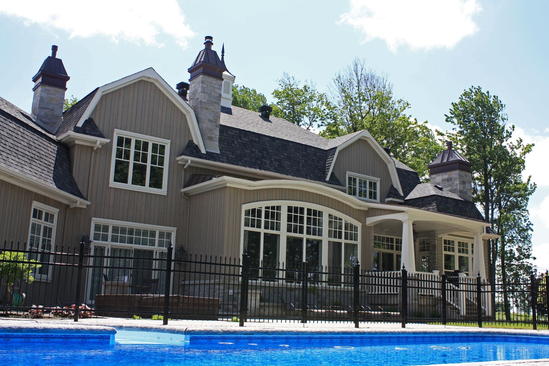 Une grande maison avec une piscine devant