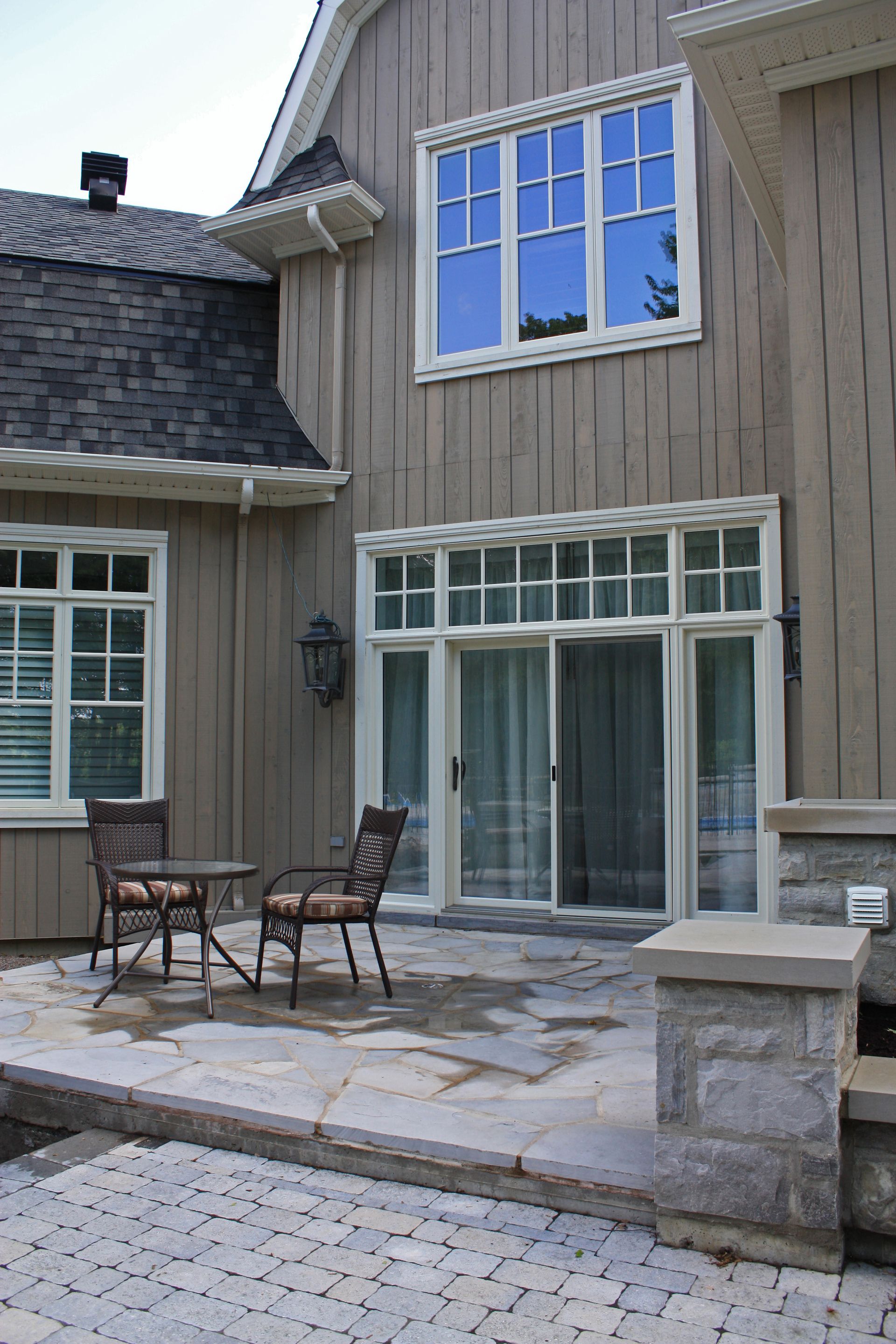 Une maison avec un patio et des chaises devant