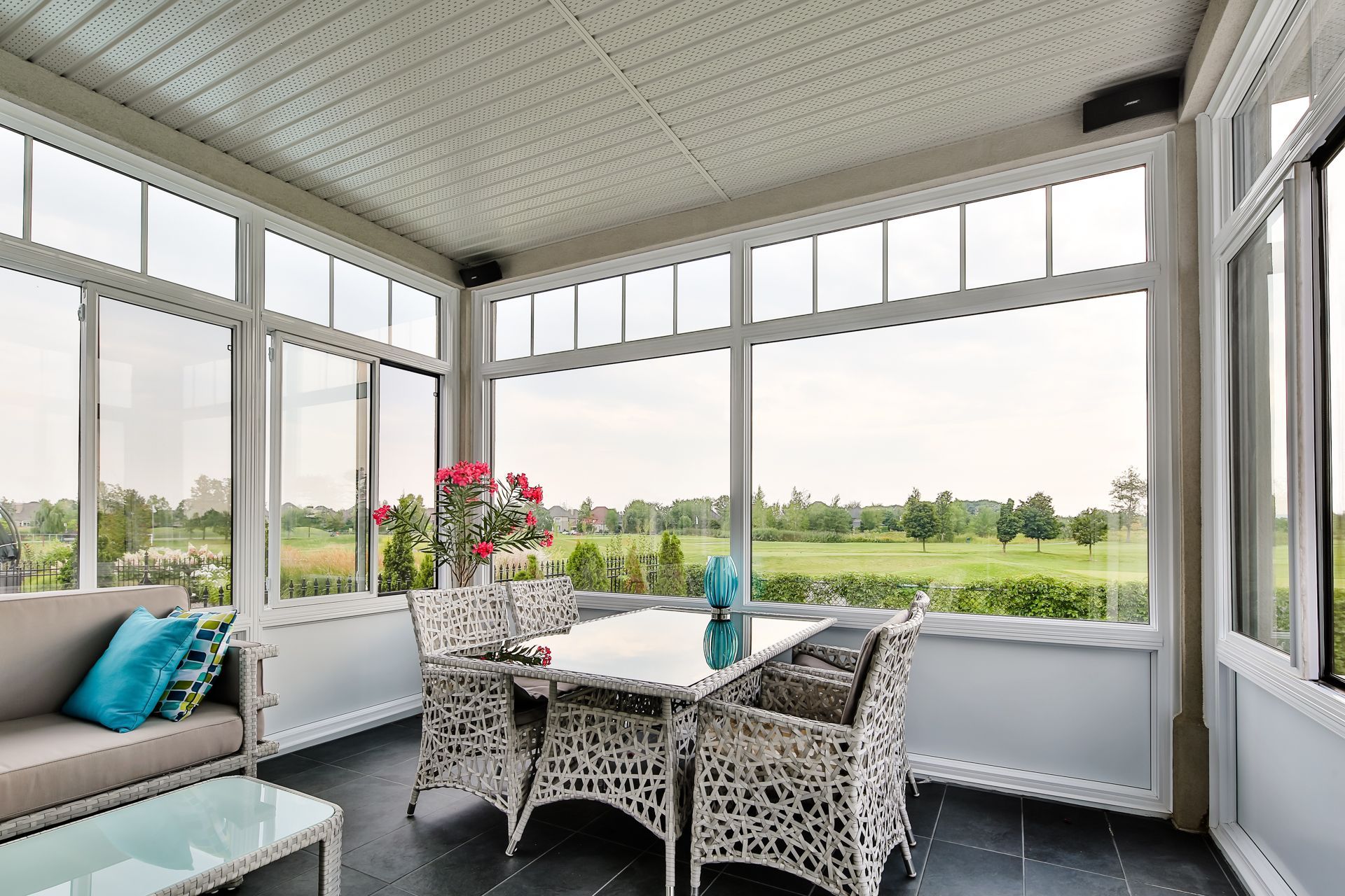 Un porche grillagé avec une table, des chaises et un canapé.