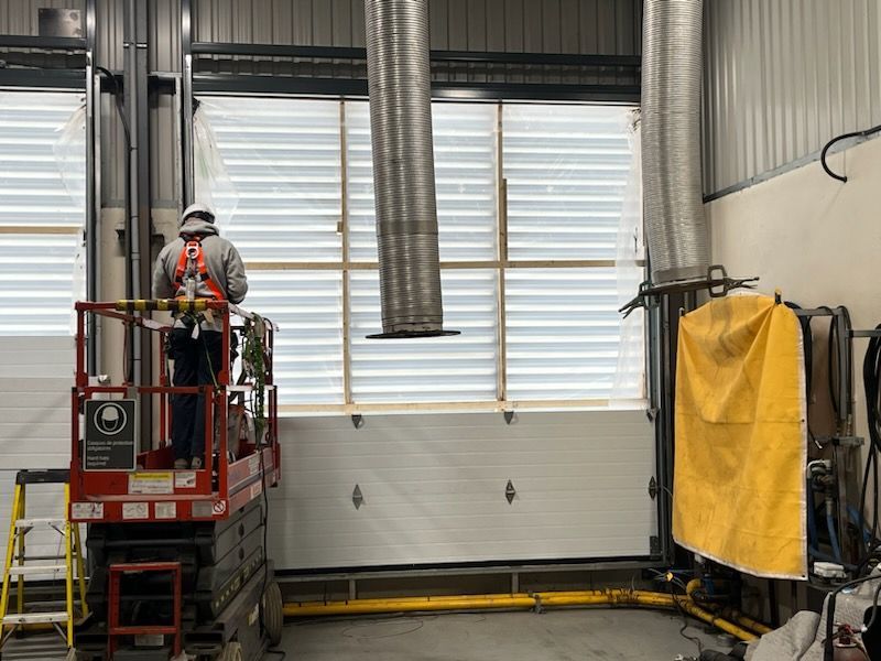 Un homme se tient debout sur un ascenseur dans un immeuble.